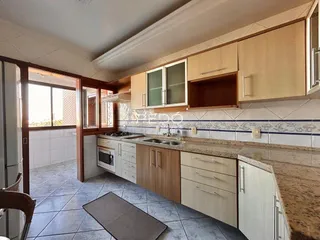 Cozinha com armários de madeira e revestimento de azulejos.