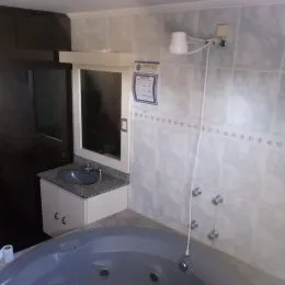 Foto de um banheiro com banheira e revestimento de azulejos brancos.