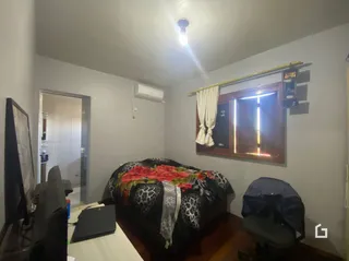 Quarto com cama e parede em um imóvel no Brasil.