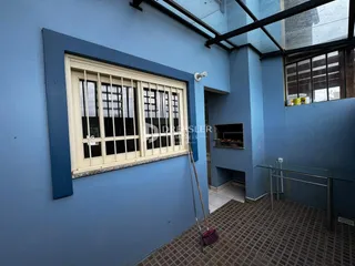 Foto de um ambiente interno com parede azul e janela grande.