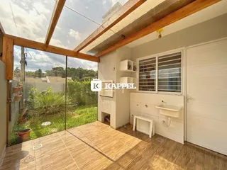 Sala com piso de madeira e vista para o jardim externo.