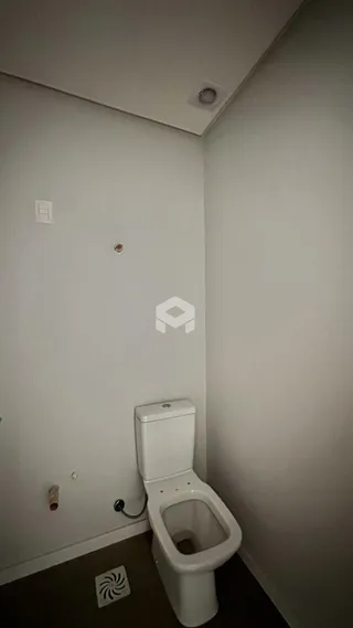 Foto de um banheiro interno com vaso sanitário e parede branca.