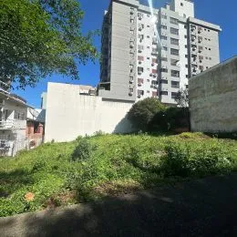 Fachada de um prédio residencial em Lajeado, Brasil, com vegetação no primeiro plano.