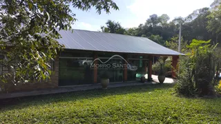 Fachada de uma residência com telhado metálico e jardim verde.