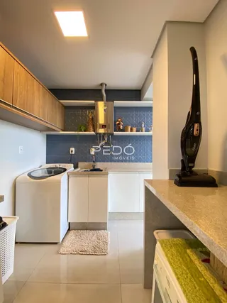 Foto interna de uma cozinha com armários de madeira e piso claro.