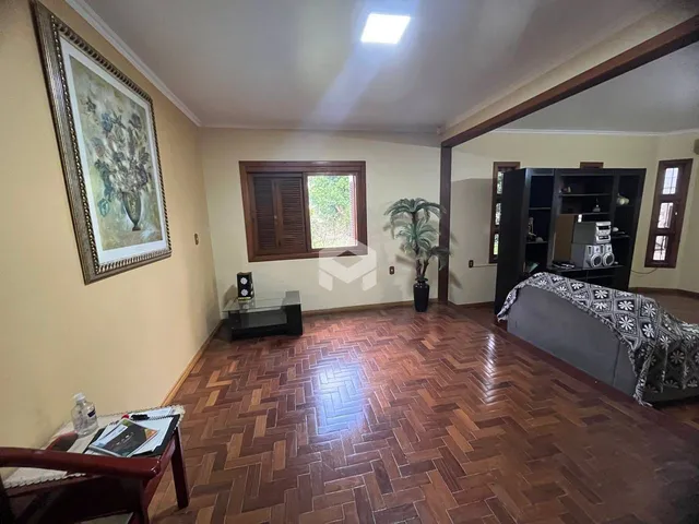 Foto da sala de estar com piso de madeira e moldura decorativa.