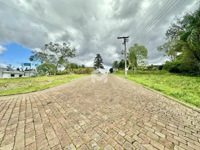 Vista de uma rua pavimentada com gramados e árvores em Lajeado, Brasil.