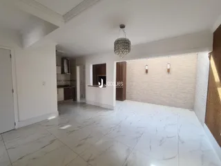 Sala de estar com piso de mármore claro e paredes brancas.