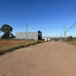 Vista externa de um prédio industrial ao longo de uma estrada de terra em Lajeado.
