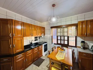 Foto de uma cozinha com armários de madeira e bancadas escuras.
