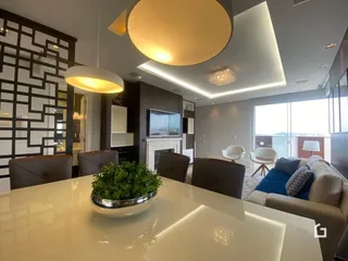 Sala de estar moderna com luminária de teto e janela grande.