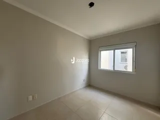 Vista interna de um ambiente com paredes brancas e piso de cerâmica.