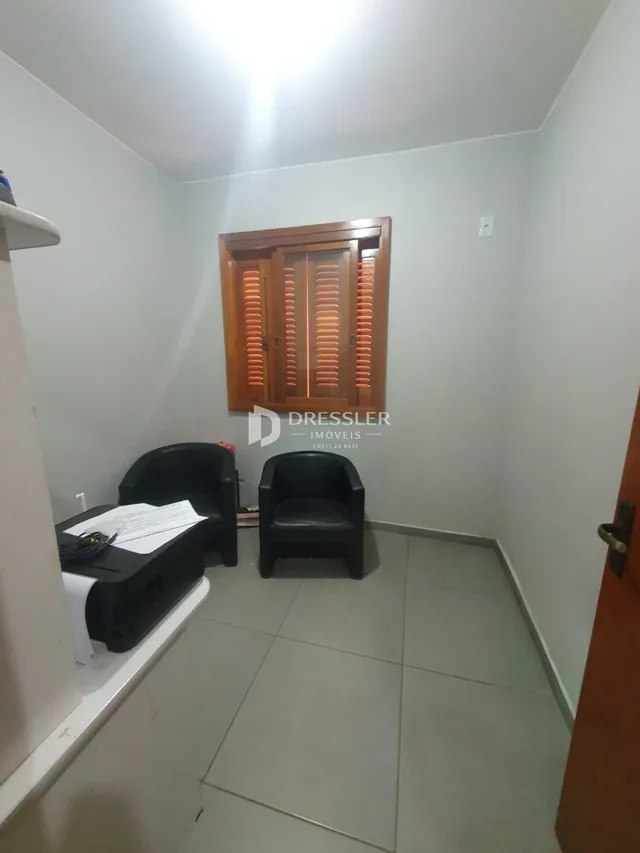 Vista interna de um corredor com piso de cerâmica e porta de madeira.