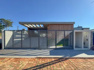 Fachada moderna de uma residência com cerca e paisagismo em Lajeado, Brasil.