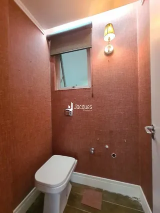 Foto de um banheiro interno com azulejos e paredes cor de terracota.