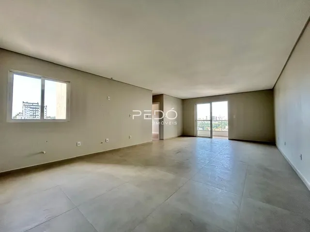Vista interna de um ambiente amplo com paredes claras e piso de concreto.