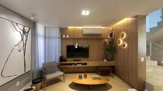 Sala de estar com painéis de madeira e televisão na residência.