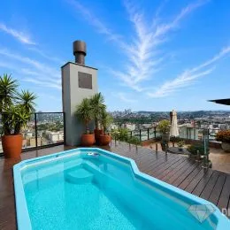 Piscina externa com vista panorâmica da cidade.