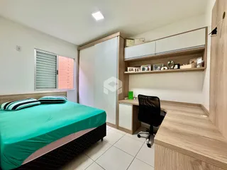 Quarto com cama, armário e área de trabalho em um imóvel no Brasil.