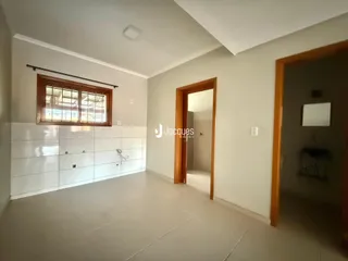 Vista interna de uma sala com piso de cerâmica e janela.