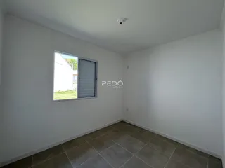 Interior de um cômodo com paredes brancas e piso de cerâmica.