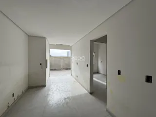 Corredor interno de um imóvel em Lajeado, Brasil, com paredes brancas e piso cru.