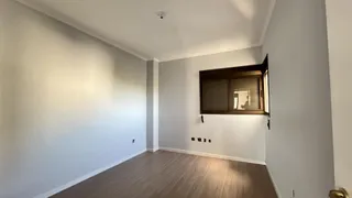 Foto de um ambiente interno com paredes brancas e piso de madeira.
