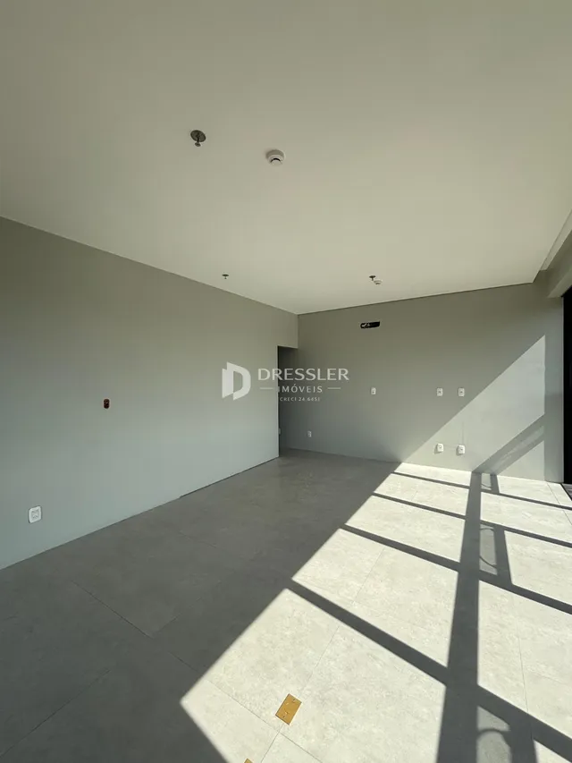 Ambiente interno de uma sala ampla com piso de cerâmica.
