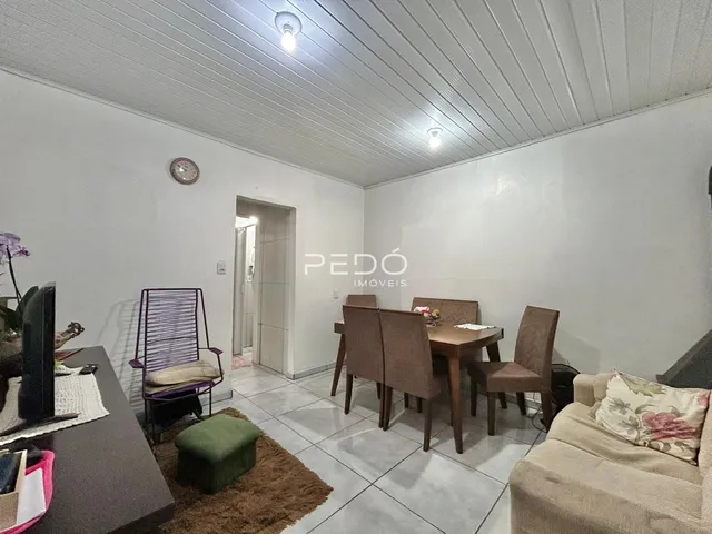 Ambiente interno de sala com móveis de madeira e piso cerâmico.