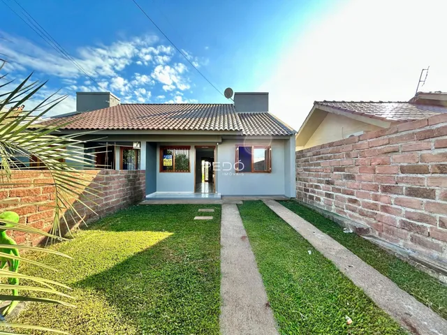 Fachada de uma casa em Lajeado, Brasil, com jardim gramado e muro de tijolos.