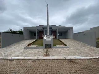 Fachada de uma residência moderna com jardim e área pavimentada em Lajeado.