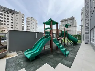 Área externa com estrutura de playground e piso de concreto.