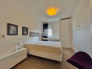 Quarto com cama e armário branco em um imóvel no Brasil.