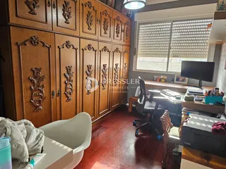 Interior de uma sala com armários de madeira e uma área de trabalho.
