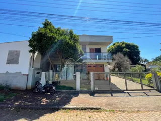 Fachada de uma residência em Lajeado, Brasil, com cerca e vegetação no jardim.