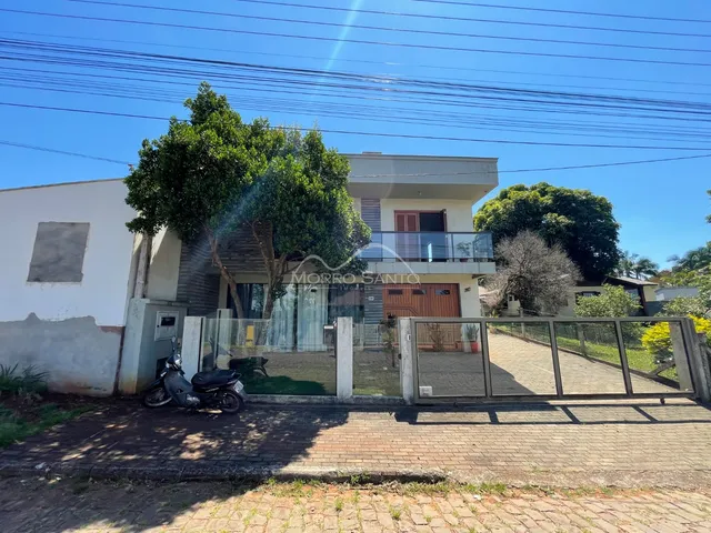 Fachada de uma residência em Lajeado, Brasil, com cerca e vegetação no jardim.