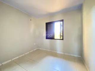 Vista interna de um cômodo com piso de cerâmica e parede clara.