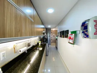Vista da cozinha moderna com armários de madeira e bancadas escuras.