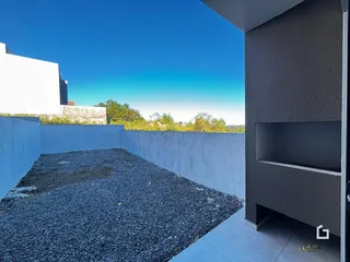 Vista externa de um pátio cercado por um muro branco em Lajeado.