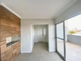 Hall de entrada com revestimento de madeira e piso claro.