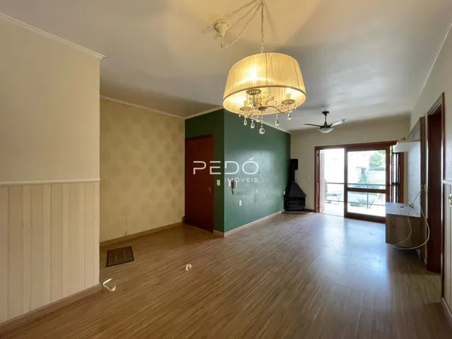 Sala de estar com piso de madeira e parede verde na residência.