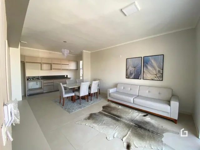 Sala de estar clara com um sofá branco.