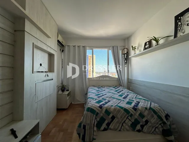 Quarto com janela e decoração de parede em apartamento em Lajeado.