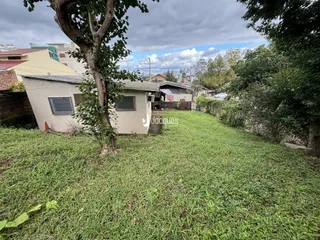 Fachada de uma casa em Lajeado, Brasil, com gramado e árvores.