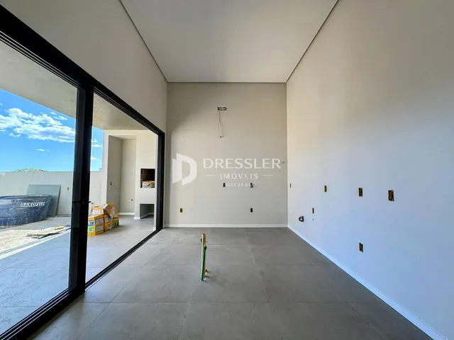 Interior de uma sala com paredes cinzas e piso claro em uma propriedade em Lajeado.