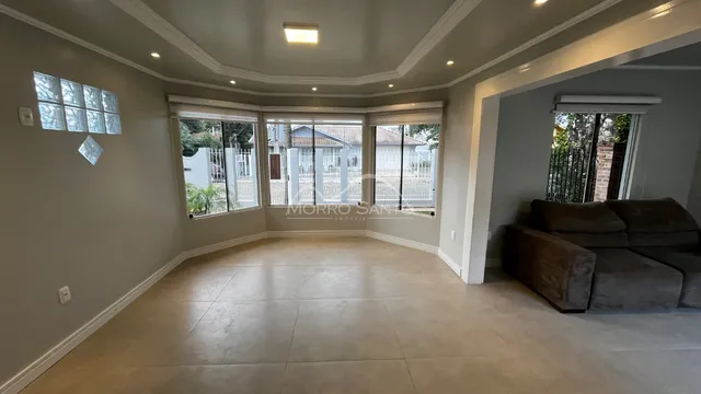 Sala de estar ampla com piso de cerâmica e vista para o quintal.