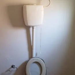 Vaso sanitário branco montado na parede.
