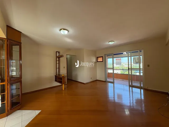 Sala de estar com piso de madeira e portas de vidro que dão para o exterior.