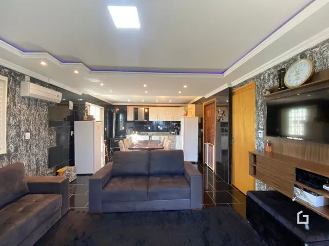 Sala de estar com sofá e televisão em um imóvel no Brasil.