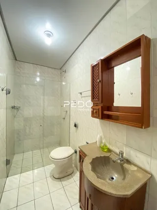 Foto de um banheiro com piso de cerâmica e box de vidro.